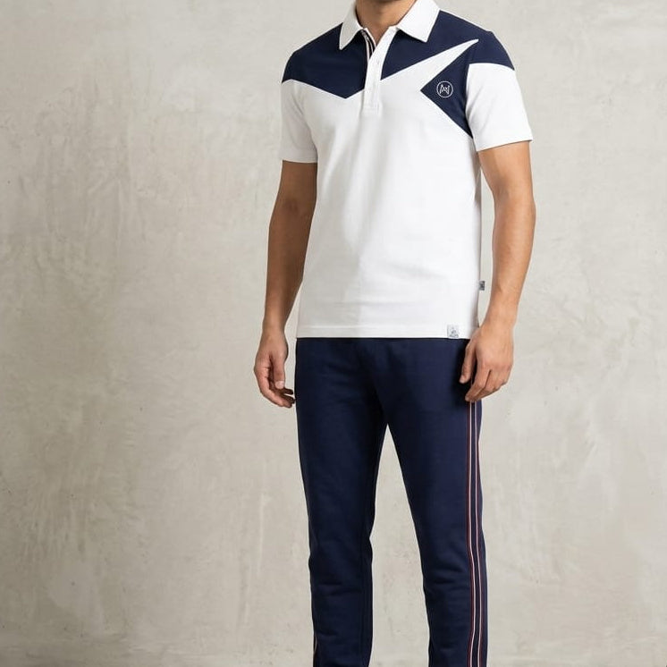 Man wearing a white and navy sports outfit with a logo on a plain background