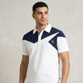 Man wearing a white and navy sports outfit with a logo on a plain background