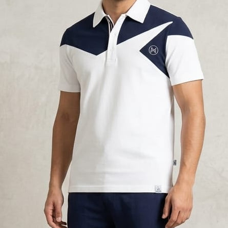 Man wearing a white and navy sports outfit with a logo on a plain background